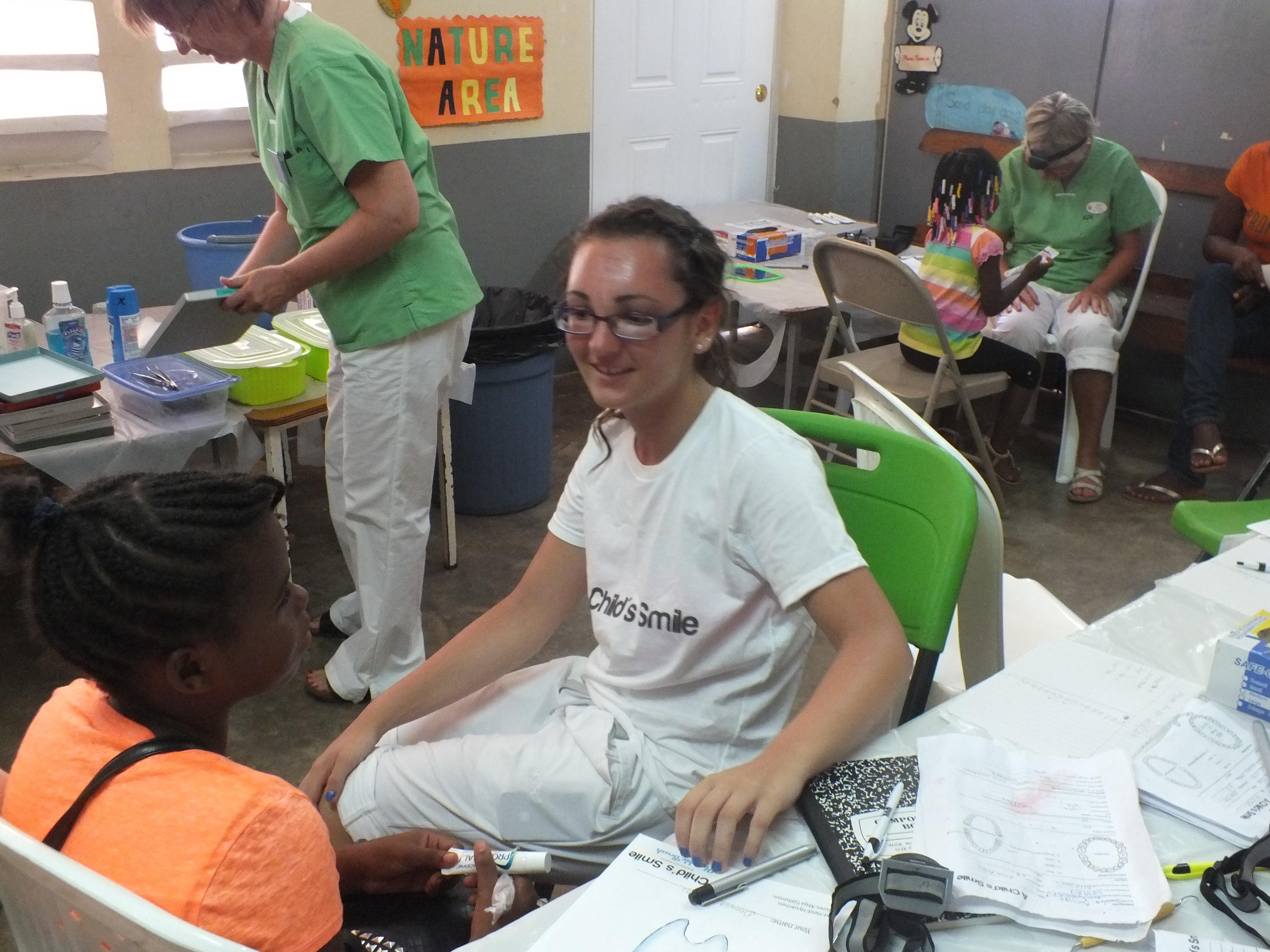 Female Denistry intern talks to a young girl in a Heathcare Centre during a Medical internship in Jamaica. Projects Abroad Dentistry intern speaks to a young patient in a Healthcare Centre during her Dentistry work experience in Jamaica.